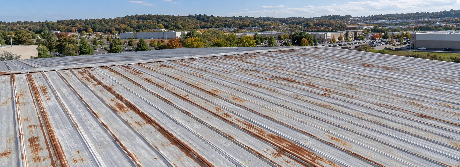 Rust streaks along the ribs and laps of an older commercial metal roof